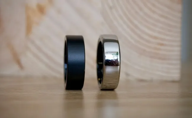 Dos anillos Oura Ring uno negro mate y el otro gris brillante.