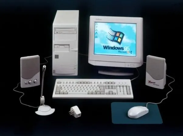 Setup antiguo con monitor de tubo, altavoces micrófono y otros periféricos con Windows 95.
